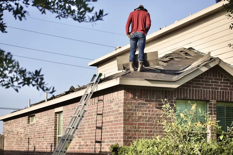 Professional roofer working on a residential roof in West Avon